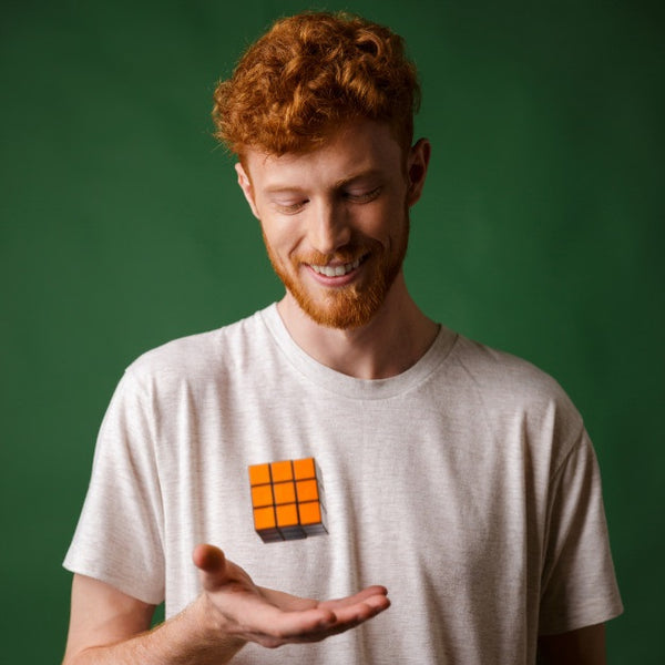 homme roux jouant au Rubik's cube